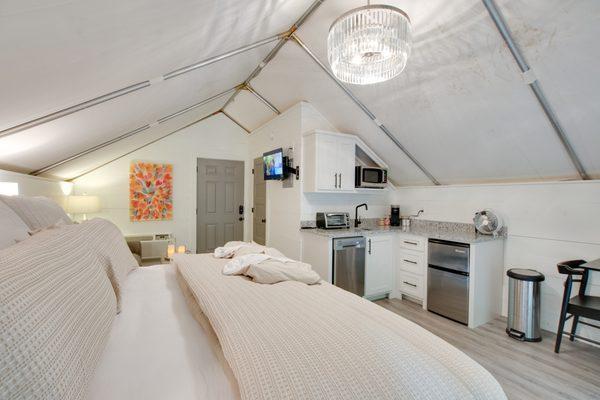 The inside of one of six on-site climage controlled glamping tents featuring private bath, kitchenette and deck.