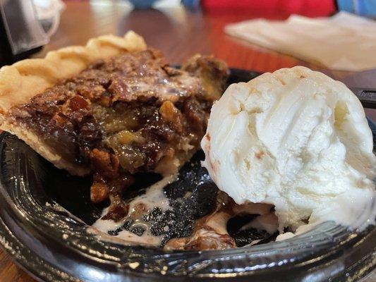 1/2 eaten chocolate pecan pie with vanilla ice cream.