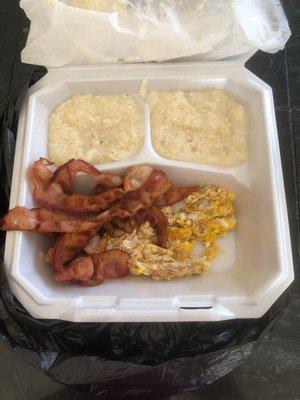 Scrambled egg and grits with bacon breakfast platter.