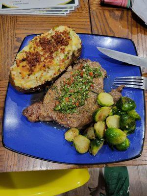 Twice baked fully loaded potato, chimichuri Ribeye, and seasoned Brussels