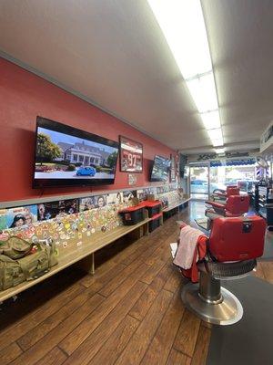 Inside the barber shop, movie playing on the TV.