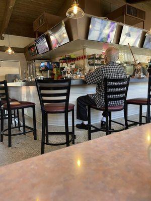 A regular enjoying his breakfast and coffee between being greeted by other regulars.