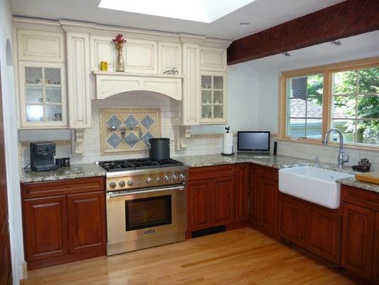 This custom kitchen has  stained rustic Cherry wood base cabinets. With off white lacquer wall cabinets with a rub - through finish.