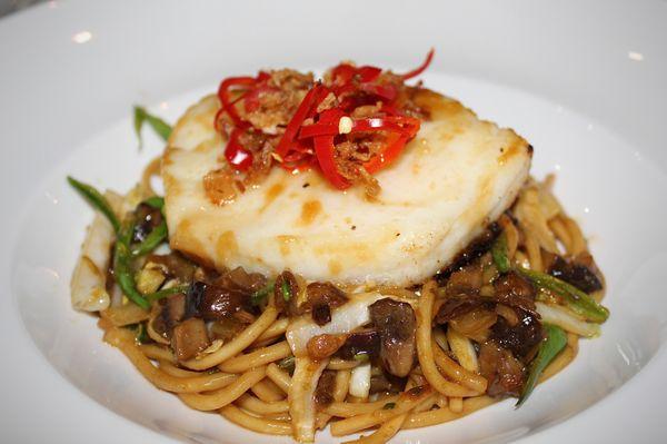 The Miso Chilean Seabass is made with Pan Fried Noodles, Vegetables, Crispy Shallot, Shiitake Mushrooms, Fresno Chile, and Miso Sauce.