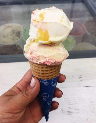 Strawberry cheesecake and pineapple cream ice cream sugar cone.