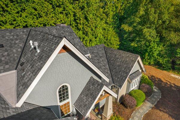 A high-angle view highlighting the intricate details of a professionally installed asphalt shingle roof on a modern home.