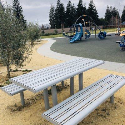 Table seating, concrete walkways, trees, Play areas.