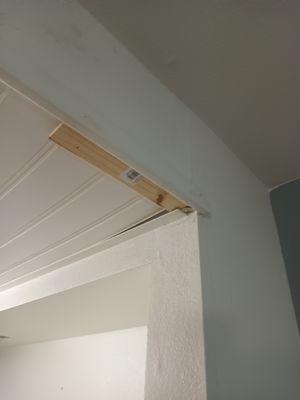 Bathroom ceiling held up by piece of wood