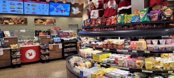 Cooler with pre-made food and view of deli counter