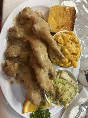 Smothered chicken, fried cabbage, mac and cheese, and corn bread.