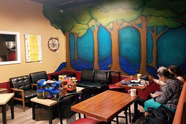 Neat mural and nook that is great for moms trying meet up. There are toys and games for kids! On the left you can see the roaster!