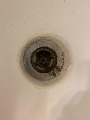 Bathroom tub drain. Simply a hole with rust.