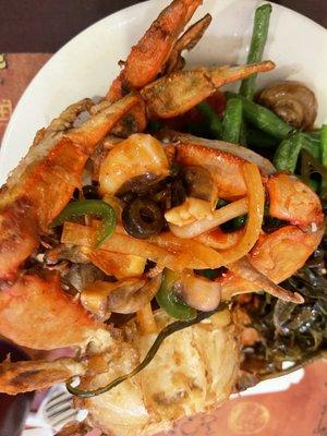 Upside down photo of my first plate: blue crabs, squid salad, seaweed salad, marinated mushrooms