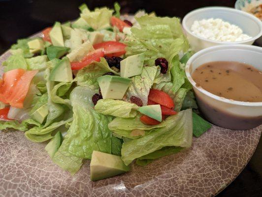 Avocado salad with romaine, tomatoes, raisins, walnuts goat cheese and balsamic