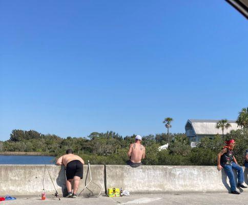 Fishing on the bridge by the store.