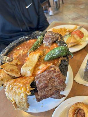 Molcajete served with a side of rice, beans and corn or flour tortillas