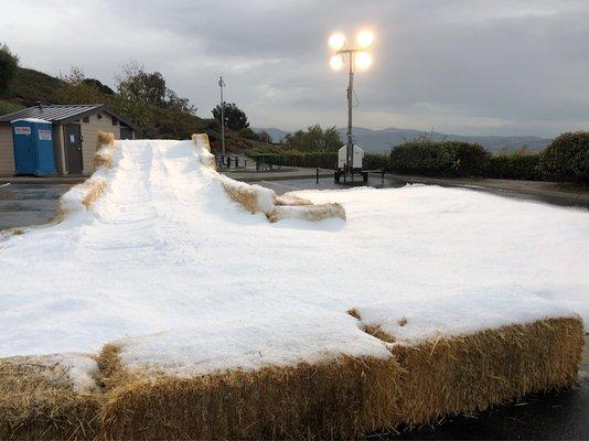 A snow filled sled run for kids by Athans Ice House.