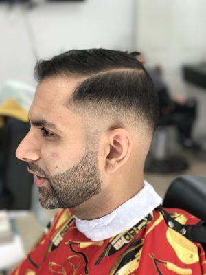 Low skin fade, beard line up and side part.