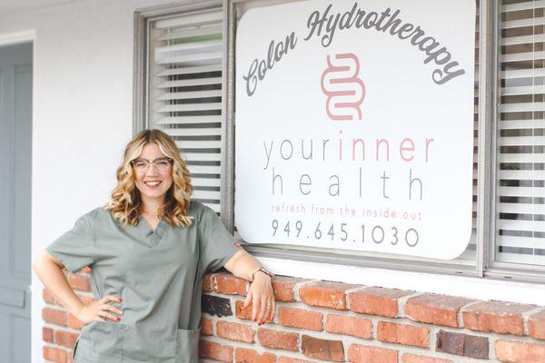 Melissa with the new front door signage at Your Inner Health