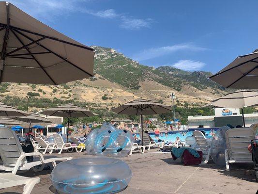 Shaded lounging by wave pool. Coveted spots that become easier to grab in afternoon.