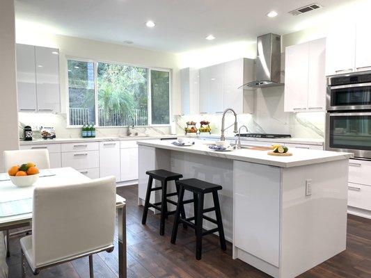 Modern glossy white cabinets, Dekton porcelain countertops & full backsplash.