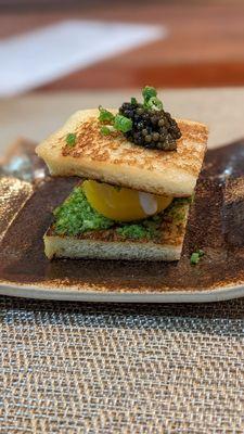 Sous vide egg with pesto in between Japanese bread with sturgeon caviar on top.