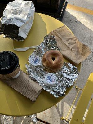 A over the counter frozen bagel and a cup of coffee and cream cheese