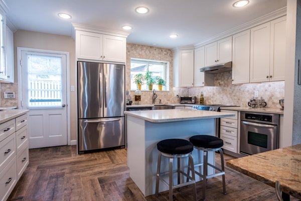 Kitchen with natural stone backsplash and undercabinet lighting. design and installed by Tile Center