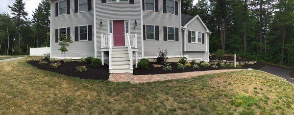 New bed installation with mulch shrubs and trees.