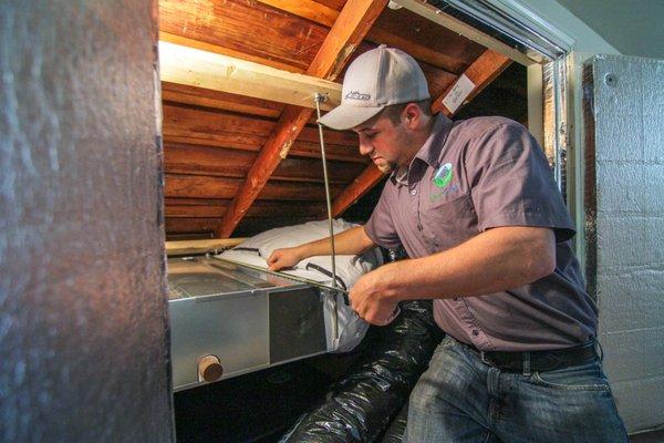 GreenSavers HVAC technician installing a Mitsubishi horizontal ducted mini split heat pump