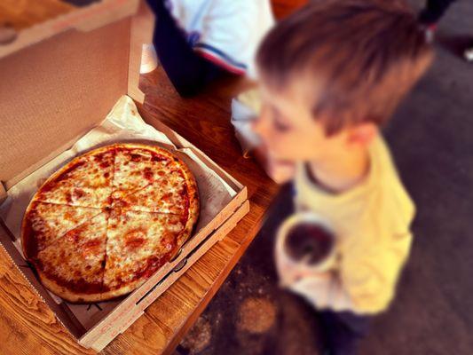 The boy was excited about his cheese pizza