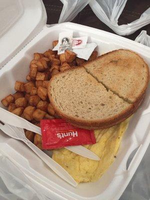 Scrambled eggs with home fries and sausage underneath