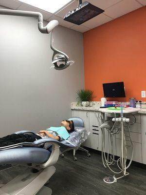 Comfy chair and TV ceiling mounted to keep kids entertained.