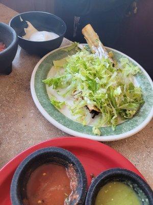 Flautas on top of sour cream under a bed of lettuce?