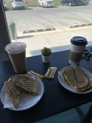 Breakfast egg white panini with ice hazelnut white mocha latte, and hot latte with oat milk and cinnamon sprinkles.