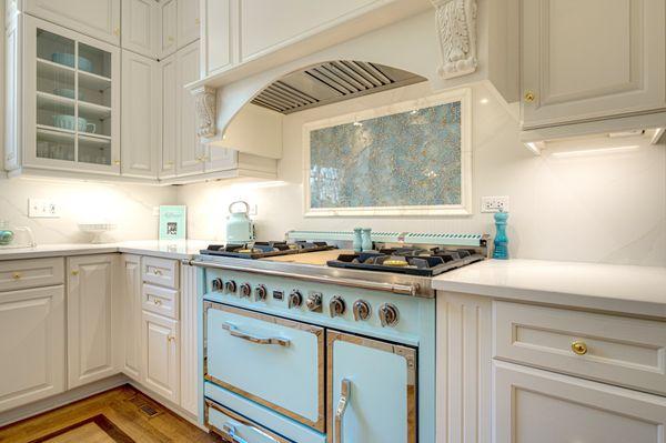 Aqua and gold crackle glass adds drama and interest in this beautiful kitchen. Light, bright and easy to clean!