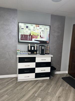 Clean Complimentary Coffee station and tv showing updated dentistry information