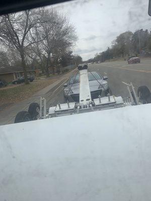 Wrecker tow truck towing a car picked up near Brooklyn park and dropping it off near Minneapolis