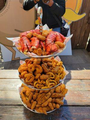 Seafood tower includes: Brown sugar hush puppies, fries, fish, scallops, shrimp AND calamari