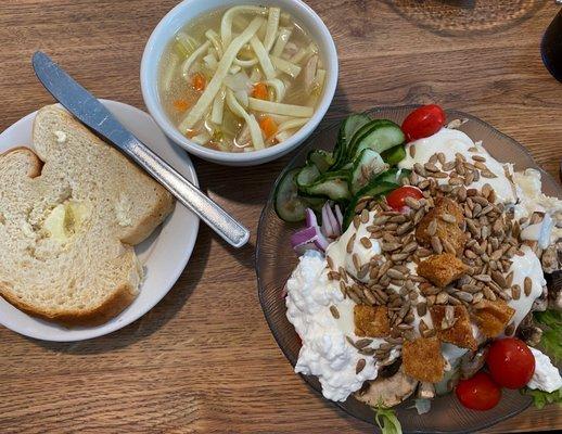 A delicious salad, chicken noodle soup, warm bread.