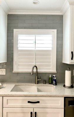 Shutters mounted on glass tile backsplash