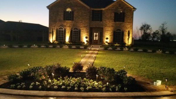 Landscape lighting of house, Flower beds, and walkway.