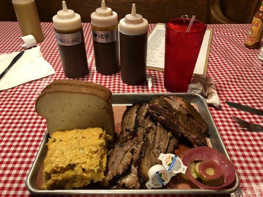 Tender Brisket, great ribs, huge warm cornbread . Cole slaw  behind bread .  Pickle and red onion . Butter .