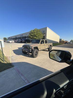 Jeep blocking access from connected parking lot, blocking fire lane intentionally. Forcing parents to drop kids off then reverse out.