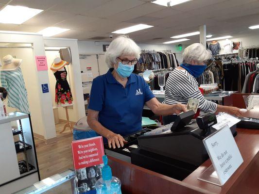 Volunteer masked marvels working well together at the cash register.