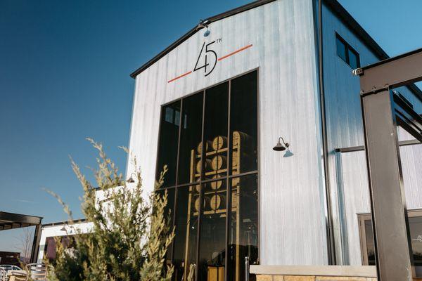 The West entrance and exterior view of 45th Parallel Distillery's restaurant, bar, and event space in New Richmond, Wisconsin.