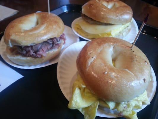 Starting w/ closest, moving clockwise: deli egg, roast beef, and sausage, egg & provolone all on a plain bagel