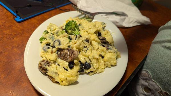 Two eggs with broccoli, mushrooms and olives.