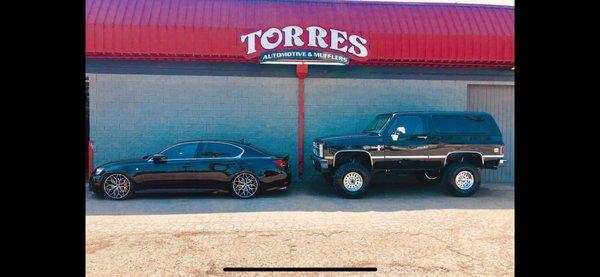 Owners cars in front of shop sign