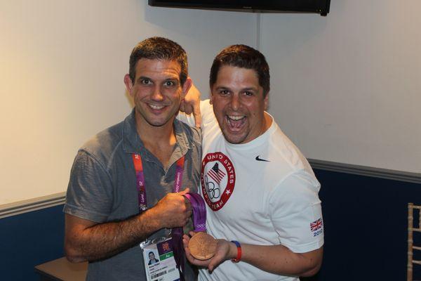 Dr. Francis holding the Hardware and Celebrating with Coach Pedro of Team USA!